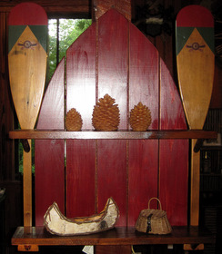 This handsome shelf features two decorative Winnipesaukee canoe 